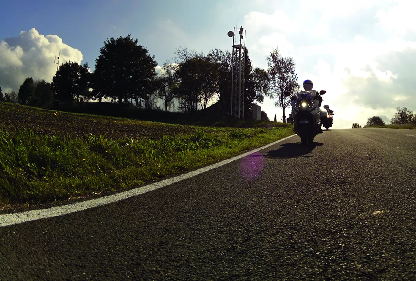 Motorrad auf einer Landstraße im tiefstehenden Abendlicht Motorrad auf einer Landstraße im tiefstehenden Abendlicht