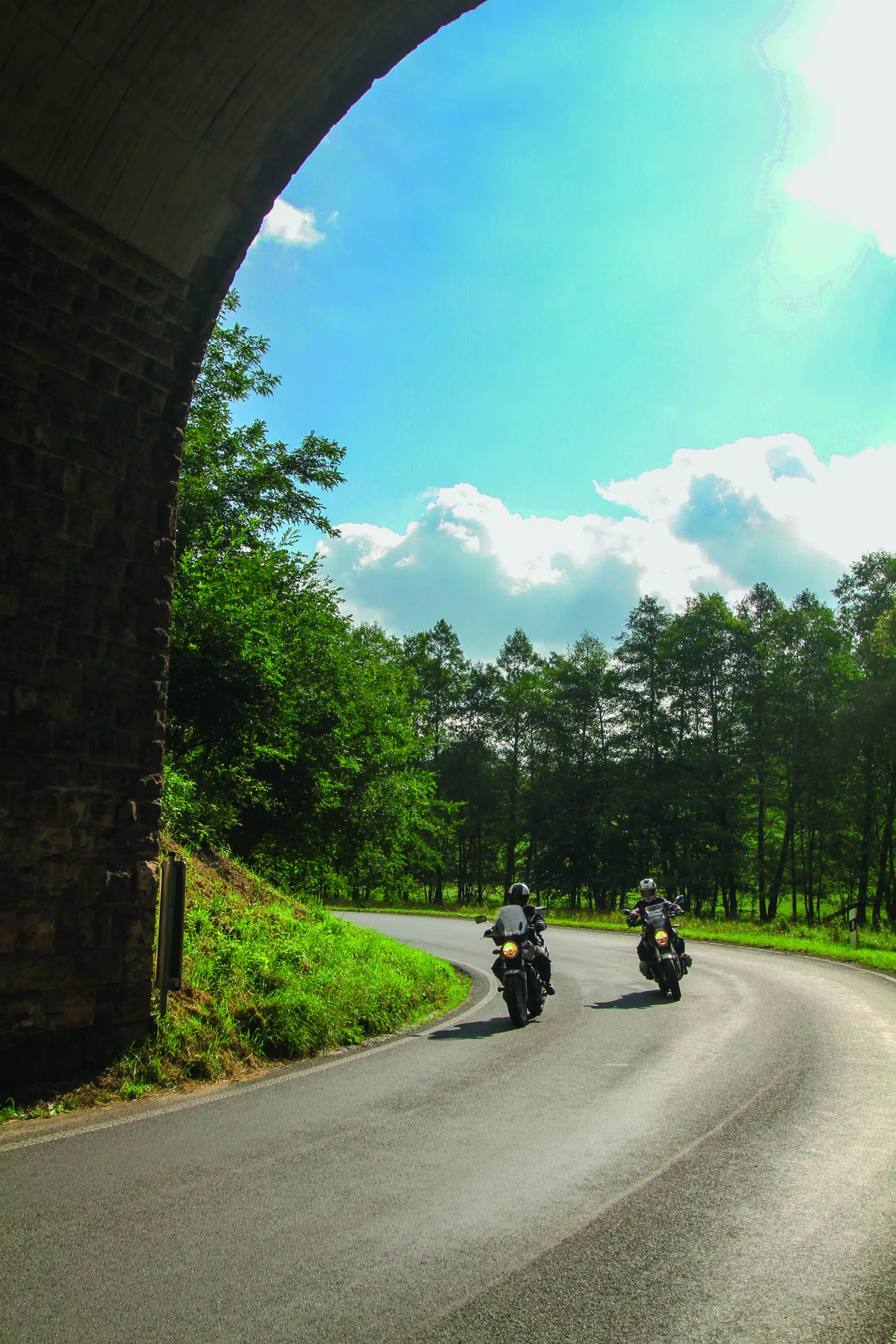 Motorrad fährt durch einen gemauerten Gewölbedurchlass Motorrad fährt durch einen gemauerten Gewölbedurchlass